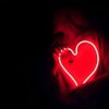 a heart shaped neon sign in the dark