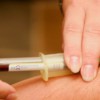 person injecting syringe