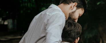 A heartfelt moment between father and son sharing a tender embrace outdoors.