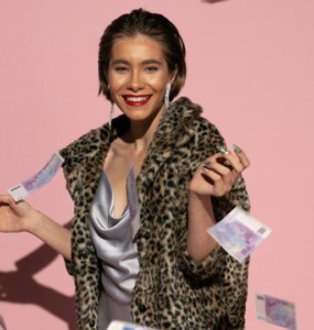 Stylish woman in fur coat with flying euro notes and pink background. Bright, fashionable, and confident.
