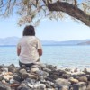 A person sits and enjoys the scenic seaside view.