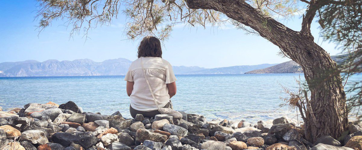 A person sits and enjoys the scenic seaside view.