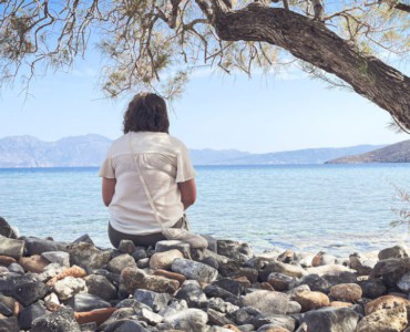 A person sits and enjoys the scenic seaside view.