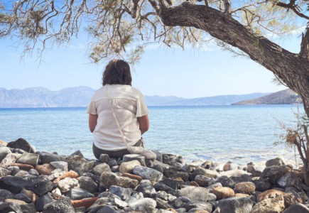 A person sits and enjoys the scenic seaside view.