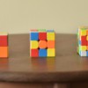a wooden table topped with three different colored blocks