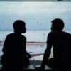 silhouette of man and woman sitting on ottoman