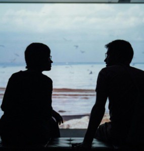 silhouette of man and woman sitting on ottoman