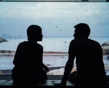 silhouette of man and woman sitting on ottoman