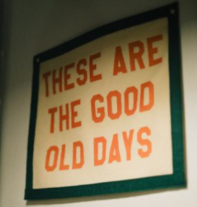 A sign hanging on a wall that says these are the good old days