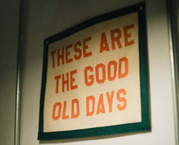 A sign hanging on a wall that says these are the good old days