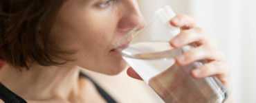 woman in black tank top drinking water