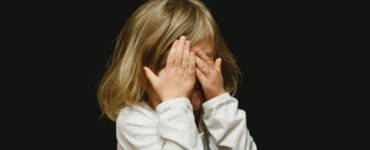 girl covering her face with both hands