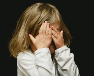 girl covering her face with both hands
