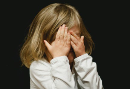 girl covering her face with both hands