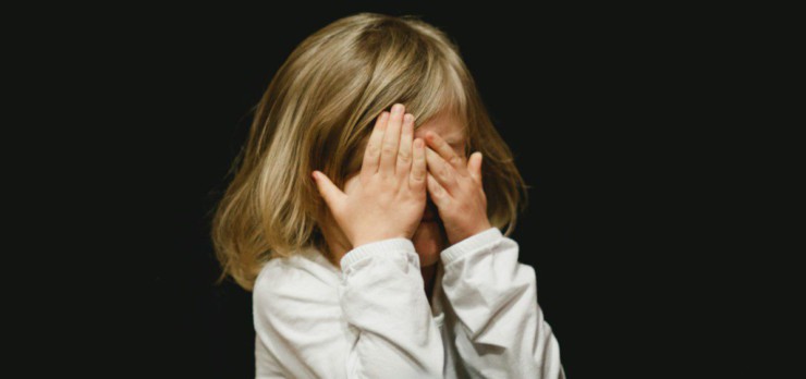 girl covering her face with both hands