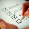 A hand marks off items on a checklist.