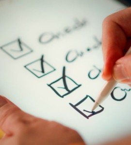 A hand marks off items on a checklist.