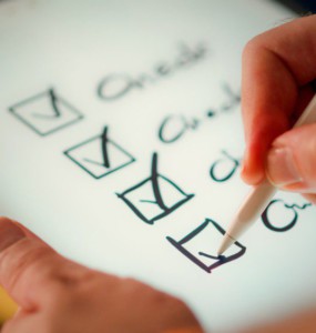 A hand marks off items on a checklist.
