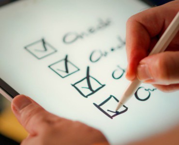 A hand marks off items on a checklist.