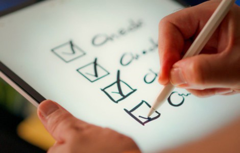 A hand marks off items on a checklist.