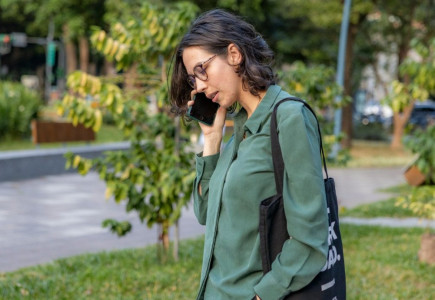 a woman talking on a cell phone in a park