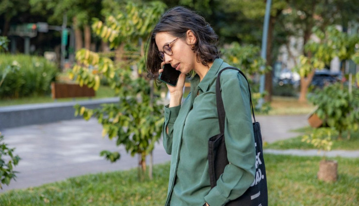 a woman talking on a cell phone in a park